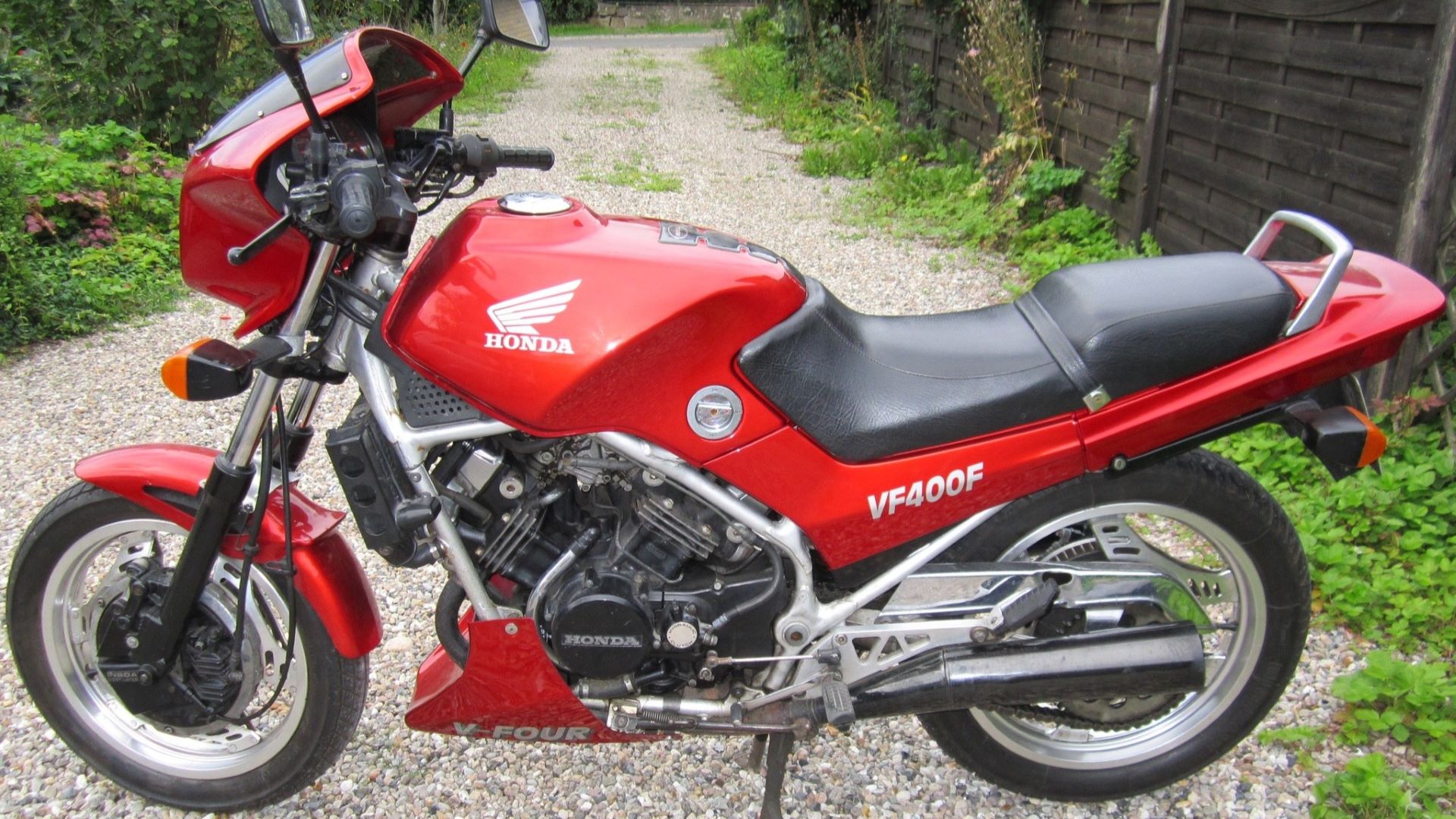 Rød Honda VF400F Motorcykel i indkørslen